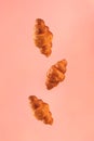 Croissants flying on pink background. Levitation scene