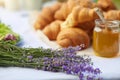 Croissants and honey on table in lavender field. Royalty Free Stock Photo