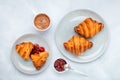 Croissants and jam. Two gray plates on a marble table. Top view, flat lay. A cup of cocoa in the morning for breakfast. Royalty Free Stock Photo