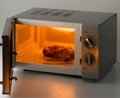 Croissants into an open microwave oven Royalty Free Stock Photo