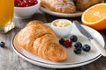 Croissants with orange juice, butter, jam and fresh fruits Royalty Free Stock Photo