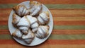 Croissants in a plate on a strips fabric surface