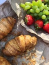 Croissants strawberries and grapes on a picnic view Royalty Free Stock Photo