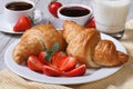 Croissants with strawberry, coffee and milk - healthy breakfast Royalty Free Stock Photo