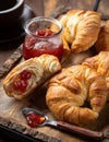 Croissants with strawberry preserves and cup of coffee