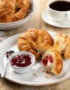 Croissants with strawberry preserves and cup of coffee