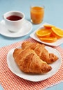 Croissants with tea and orange juice for breakfast Royalty Free Stock Photo