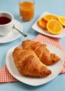 Croissants with tea and orange juice for breakfast Royalty Free Stock Photo