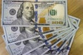 Crolled stack of 100 new dollar bills on wooden background Royalty Free Stock Photo