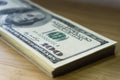 Crolled stack of 100 new dollar bills on wooden background Royalty Free Stock Photo