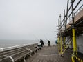 Father and son sea fishing off the end of Cromer pier on the North Norfolk coast