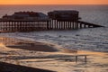 Cromer Pier at sunset with people walking on the beach
