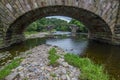 Cromwells bridge in the Ribble Valley, Lancashire. Old stone bridge over the river Hodder shot through an arch of the newer lower Royalty Free Stock Photo