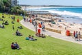 People relaxing and sunbathing on a green grass near the ocean beach after end of 3 month lockdown