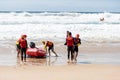 Surf rescue life savers training in progress. Surf rescue boat surrounded by crew and patient