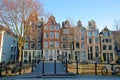 Crooked and colorful heritage buildings, with the bridge Mekmeisjesbrug in the foreground and located along Brouwersgracht Canal,