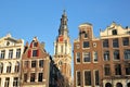 Crooked and colorful heritage buildings, located along Kloveniersburgwal Canal, with Zuiderkerk church clocktower in background Royalty Free Stock Photo