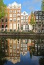 Crooked and colorful heritage buildings, overlooking Herengracht canal with perfect reflections, Amsterdam