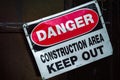 Crooked old metal warning sign that reads DANGER CONSTRUCTION AREA KEEP OUT Royalty Free Stock Photo