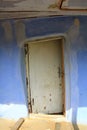 A crooked wooden door and blue wall