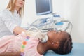 Afro child lying when doctor scanning her neck.