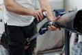Crop anonymous master spraying penetrating oil on modular knee