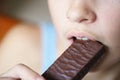 Crop anonymous teenage girl biting nutritious protein bar