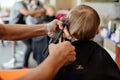 Crop barber doing haircut to little boy Royalty Free Stock Photo