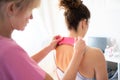 Crop body therapist using kinesiology tape on neck of patient Royalty Free Stock Photo