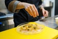 Crop chef garnishing dish of prawn carpaccio with capers Royalty Free Stock Photo