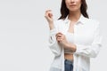 Stylish woman in white shirt and jeans confidently looking at camera