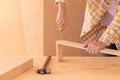 Workman with screwdriver making furniture. Crop faceless male carpenter screwing bolt with screwdriver into wooden plank