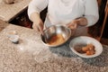 Crop female cook cracking egg into bowl