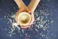 Crop female holding cup of hot coffee above confetti