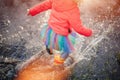 Crop girl splashing puddle in sunlight