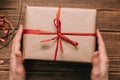 Crop hands holding wrapped present on table