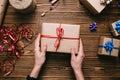 Crop hands holding wrapped present on table