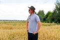 Crop and harvest. Portrait of farmer standing in gold wheat field with blue sky in background. Young man wearing Royalty Free Stock Photo