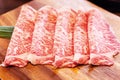 Crop image of Premium Rare Slices Wagyu A5 beef with high-marbled texture on square wooden plate served for Sukiyaki and Shabu Royalty Free Stock Photo