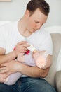 Crop of little cute baby lying on father`s hand and eating. Royalty Free Stock Photo