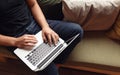 Crop man with laptop on sofa