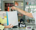 Crop pharmacist giving paper bag with pills to client Royalty Free Stock Photo