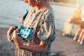 Crop photo of romantic young woman musician with african braids in dress playing on ukulele on sunset beach