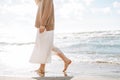 Crop photo of Young beautiful woman in beige sweater enjoying life on sea beach on sunset Royalty Free Stock Photo