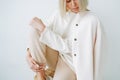 Crop portrait of young blonde woman in fleece jacket on background of white wall