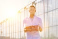 Crop scientist carrying tomatoes in crate with yellow lens flare in background