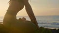 Silhouette yoga practice at sunset. Yong woman doing yoga exercise on the beach Royalty Free Stock Photo