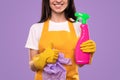 Happy housekeeper with detergent showing thumb up