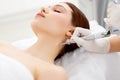 Cosmetologist removing mole with laser machine