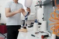 Crop unrecognizable craftsman adjusting and bending modern prosthetic leg at knee section Royalty Free Stock Photo